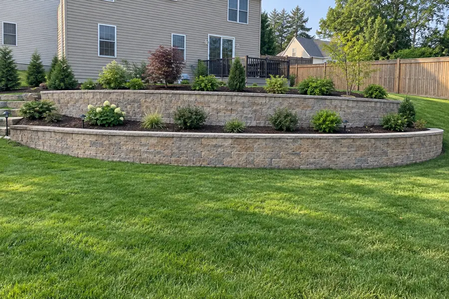 Two-tier segmental block retaining wall holding a planted slope.