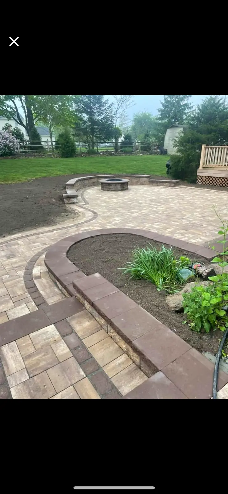 Paver patio with a built-in fire pit and a curved seat wall.