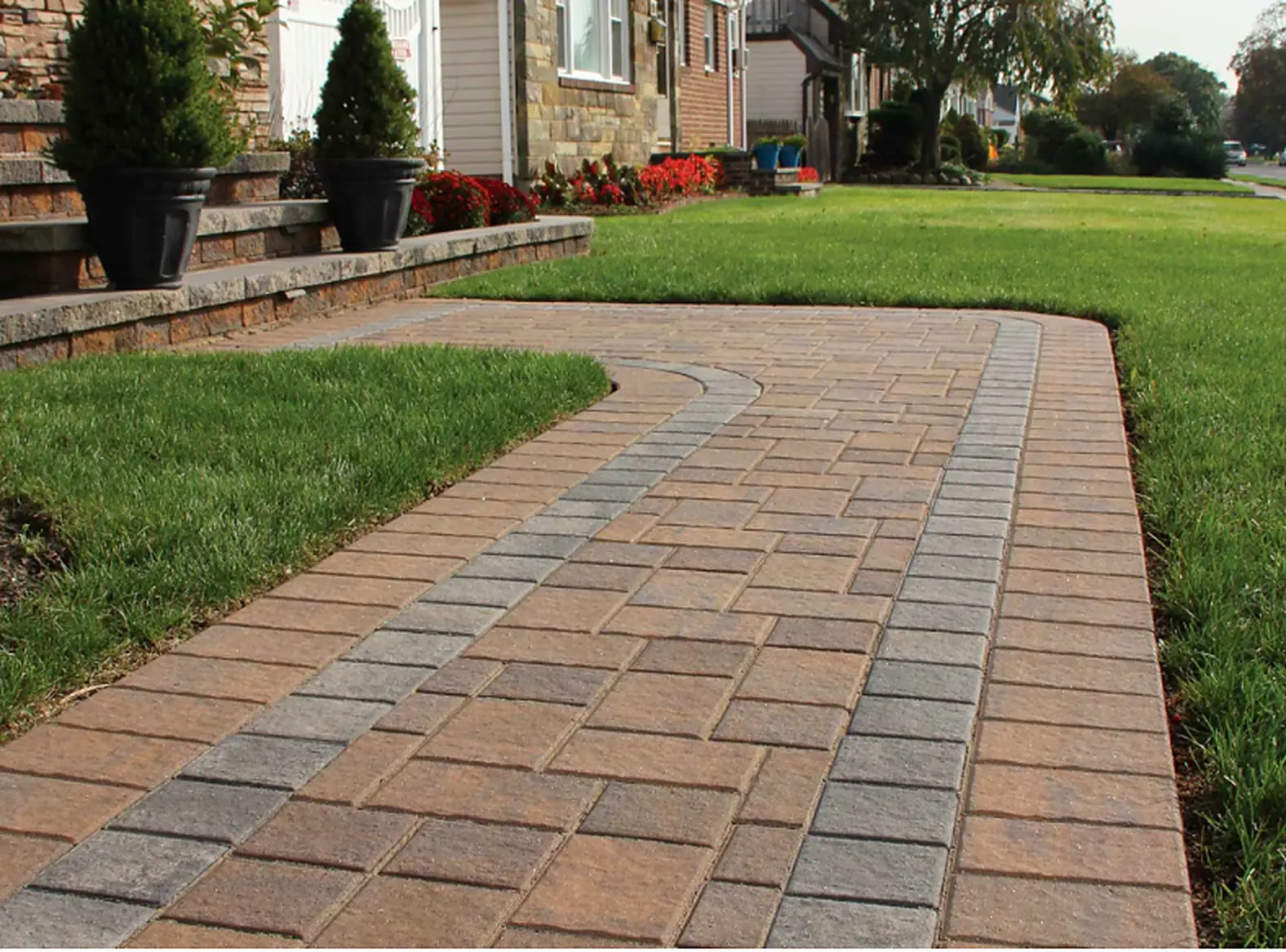 Curved paver walkway across a front lawn, a Courtyard Home Improvements job.