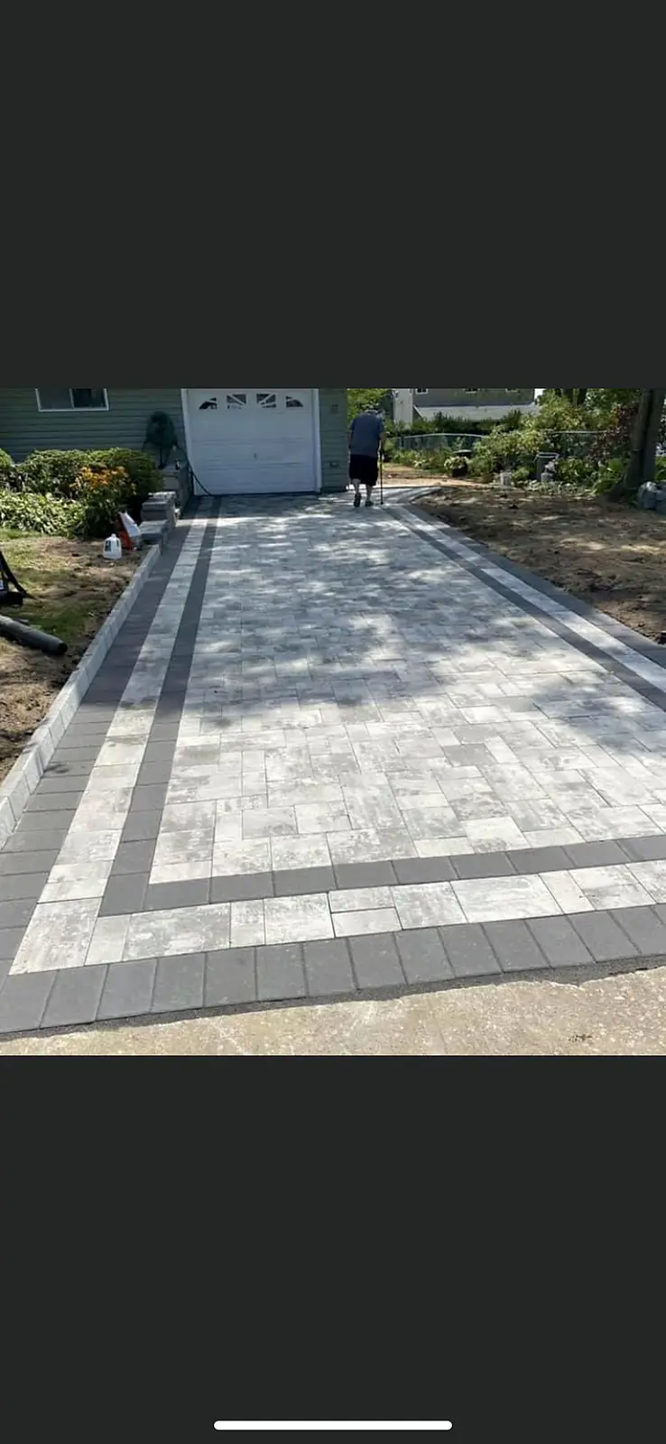 Paver driveway laid in a light blend with a dark charcoal border.